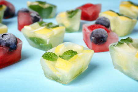 Fruit and berry ice cubes on color backgroundの写真素材