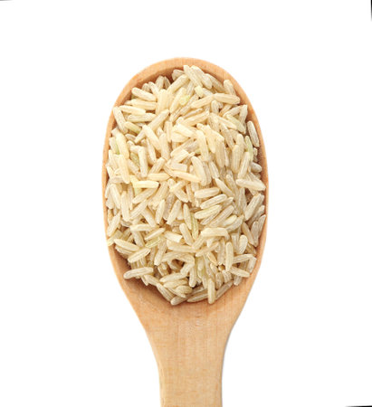 Wooden spoon with brown rice on white background, top viewの写真素材