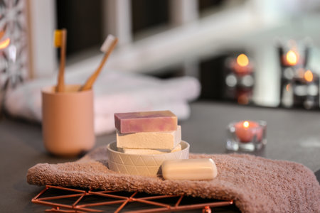 Soap bars and towel on table against blurred background. Space for textの写真素材