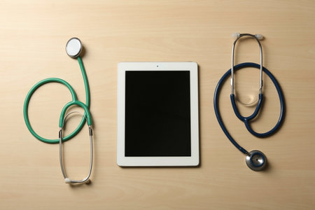 Flat lay composition with stethoscopes and tablet on table, space for text. medical students stuffの写真素材