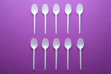 Plastic spoons on color background, top view. Picnic table settingの写真素材