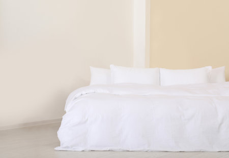 Large comfortable bed with pillows in modern room. Stylish interior design