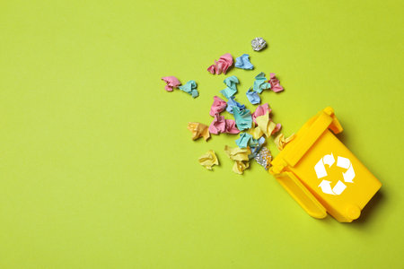 Trash bin and different garbage on color background, top view with space for text. Waste recycling conceptの写真素材