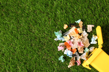 Trash bin and different garbage on green grass, top view with space for text. Waste recycling conceptの写真素材