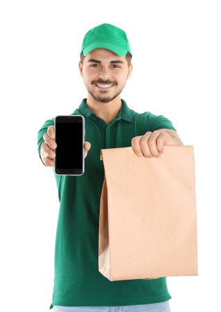 Young man holding paper bag and smartphone isolated on white, mockup for design. Online food deliveryの写真素材