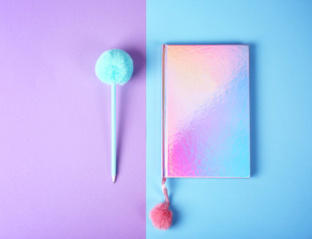 Stylish notebook with pompom and pen on color background, flat lay. Space for textの写真素材