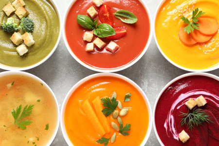 Various cream soups in bowls on gray background, top viewの写真素材