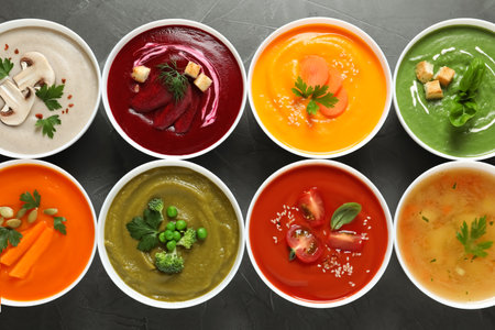 Various cream soups in bowls on gray background, top viewの写真素材