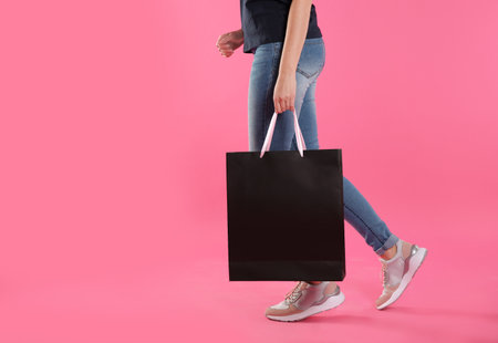 Woman with paper shopping bag on color background. Mock up designの写真素材