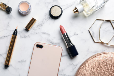 Flat lay composition with lipstick and smartphone on marble backgroundの写真素材