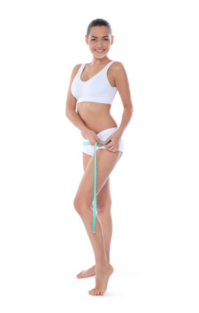 Slim woman measuring her hips on white background. weight lossの写真素材