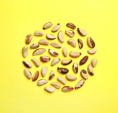 Flat lay composition with brazil nuts on color background