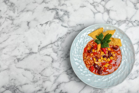 Plate with tasty chili con carne on marble background, top view. Space for textの写真素材