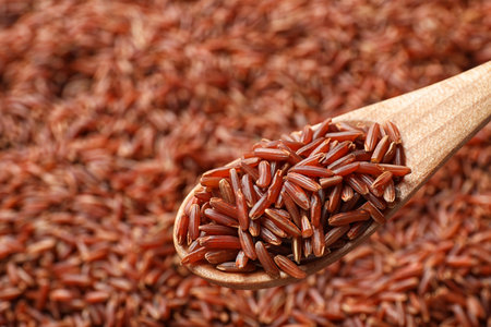 Wooden spoon with raw brown rice over cereal, closeupの写真素材