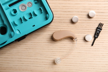 Hearing aid, case and accessories on wooden background, top viewの写真素材