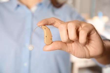 Woman holding hearing aid, closeup of handの写真素材