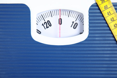 Scales with tape measure, closeup view. Diet and weight loss