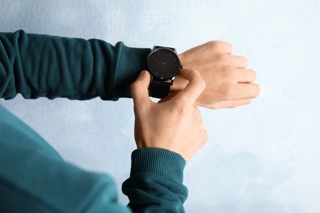 Man with stylish wrist watch on color background, closeup. time managementの写真素材