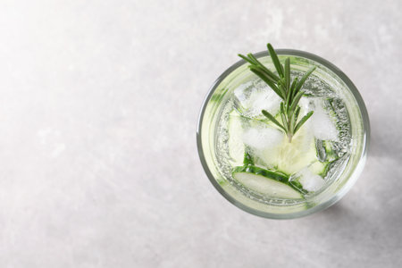 Glass of fresh cucumber water on gray background, top view. Space for textの写真素材