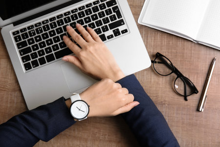Businesswoman with stylish wrist watch working at office table, top view. time managementの写真素材