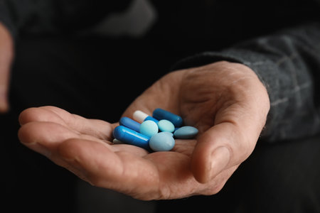 Senior man holding pills in his hand, closeupの写真素材