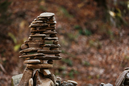Tower of balancing stones in forest. Space for textの写真素材