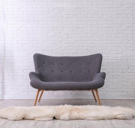 Simple living room interior with comfortable sofa near brick wallの写真素材