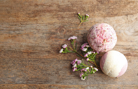 Flat lay composition with bath bombs, flowers and space for text on wooden backgroundの写真素材