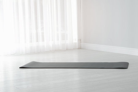 Rubber yoga mat on floor indoors. Space for textの写真素材