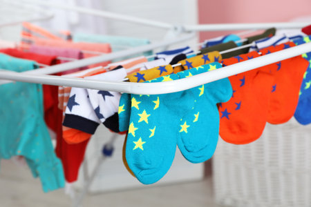 Different colorful socks on drying rack against blurred background, closeupの写真素材