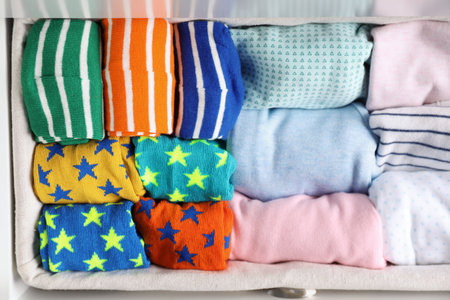 Many different colorful socks in open drawer, top view