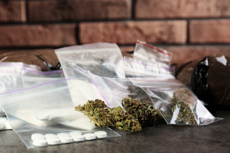 Hemp and other drugs in packages on gray tableの写真素材