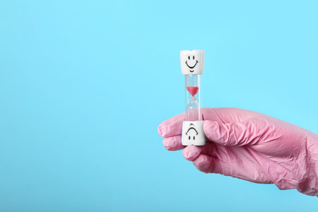 Dentist holding sand glass on color background, space for text. brushing teeth time