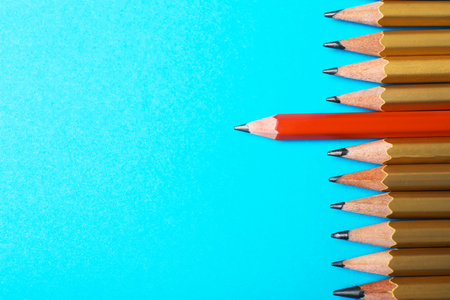 One different pencil standing out from others on color background, top view. Space for textの写真素材