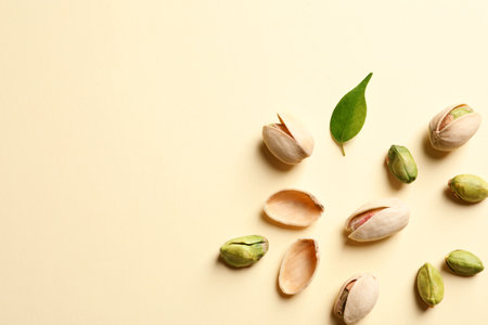 Composition with organic pistachio nuts on color background, flat lay. Space for text