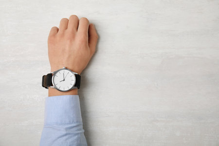 Man with stylish wrist watch at table, space for text. time managementの写真素材