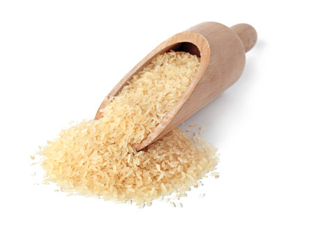 Scoop with uncooked parboiled rice on white backgroundの写真素材
