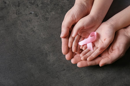 Woman and girl holding pink ribbon on gray background, top view with space for text. breast cancer awarenessの写真素材