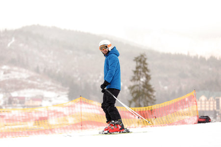 Skier on slope at resort. winter holidays