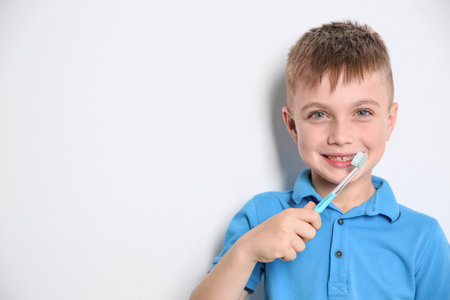 Portrait of little boy with toothbrush on light background. Space for textの写真素材