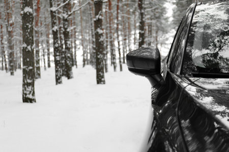 Snowy country road with car on winter day, closeup with space for text