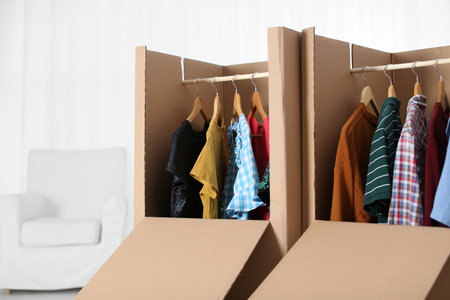 Wardrobe boxes with clothes on hangers indoorsの写真素材