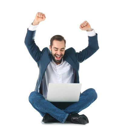 Emotional businessman in office wear with laptop celebrating victory on white backgroundの写真素材