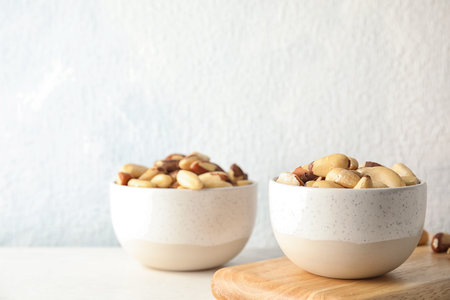 Bowls with tasty Brazil nuts on table. Space for textの写真素材