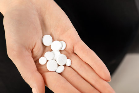 Woman holding many pills in hand, closeup viewの写真素材