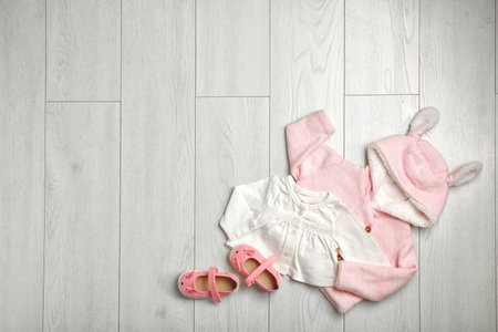 Flat lay composition with cute clothes and space for text on wooden background. baby accessoriesの写真素材