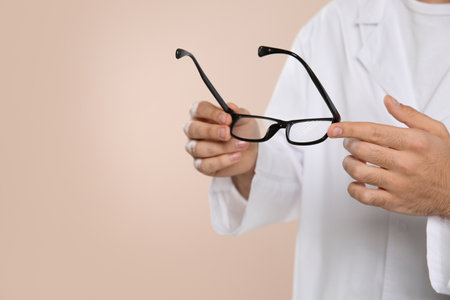 Male ophthalmologist with eyeglasses on light background, closeup. Space for textの写真素材