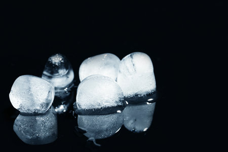 Melting ice cubes on black background. Space for textの写真素材