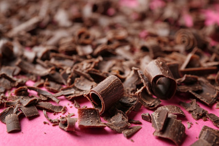 Curls of tasty chocolate on color background, closeupの写真素材
