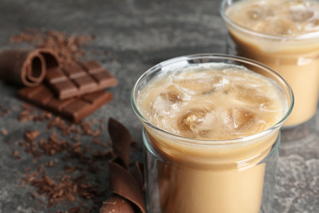 Glass cup with iced coffee on gray table